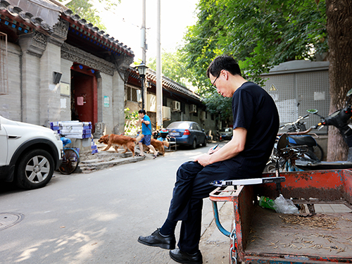 工作之余坐在街边勾勒北京的胡同风貌