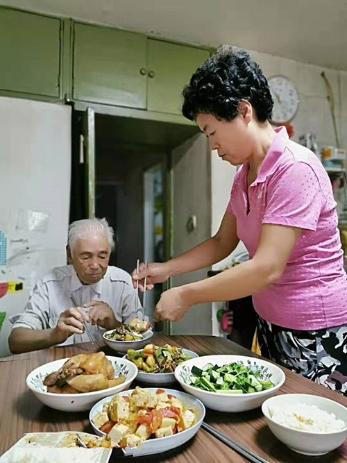 吃饭时给叔公夹菜喂食(右)